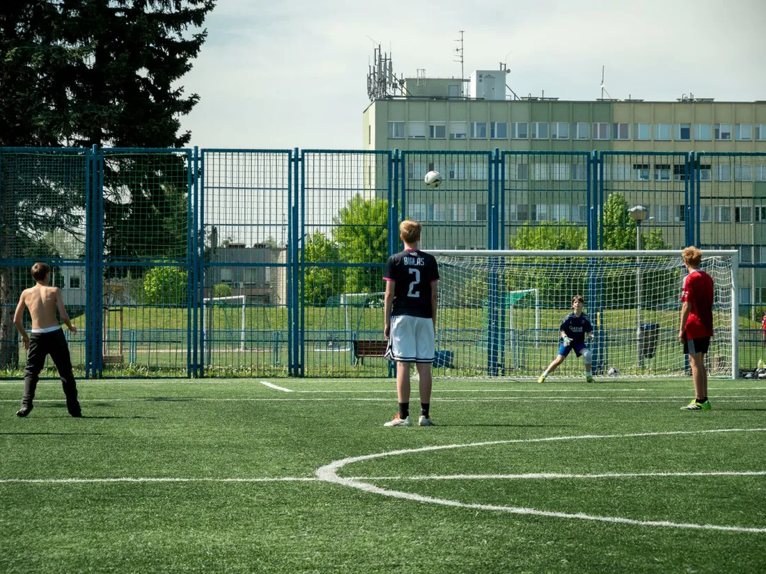 Young people playing soccer outdoors